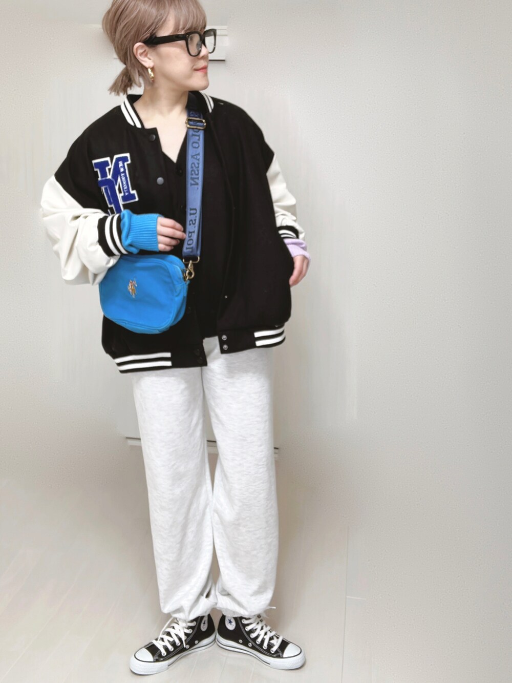 ブルー系のショルダーバッグ、ブラック系のスタジャン、ブラック系のカーディガン/ボレロを着用したレディースの春コーディネートの5枚目の写真