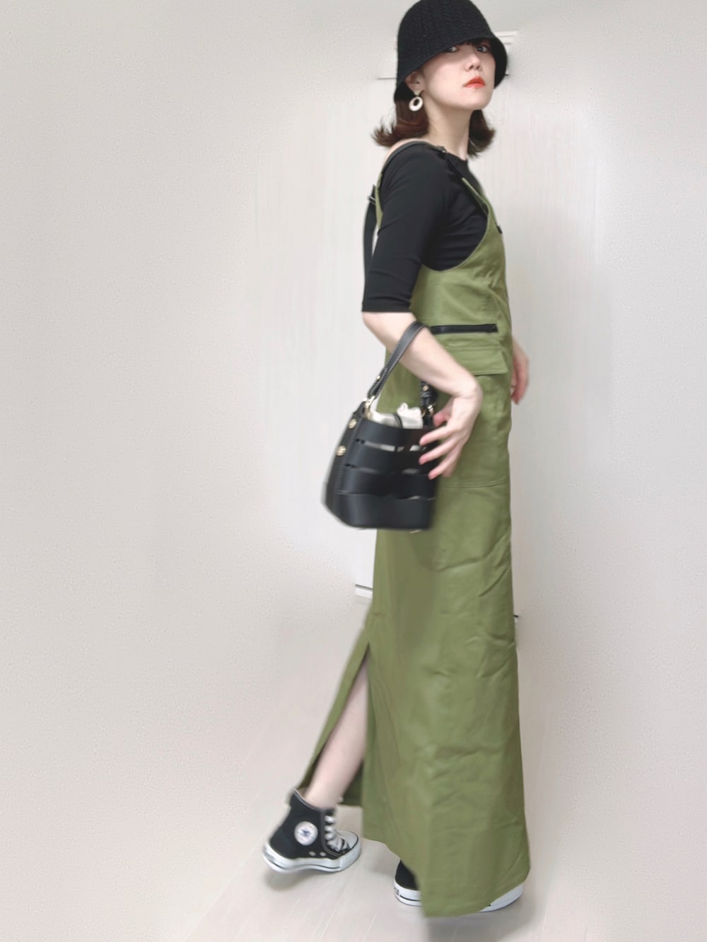 グリーン系のジャンパースカート、ブラック系のTシャツ/カットソー、ブラック系のショルダーバッグを着用したレディースの夏コーディネートの5枚目の写真