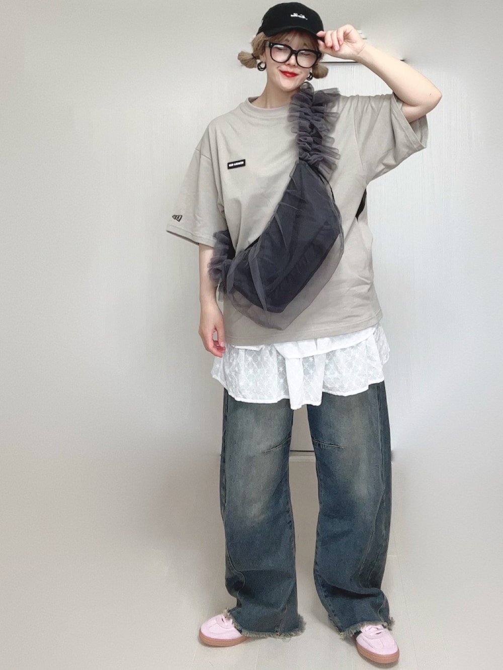 ブルー系のデニムパンツ、ホワイト系のスカート、グレー系のショルダーバッグを着用したレディースの夏コーディネートの2枚目の写真