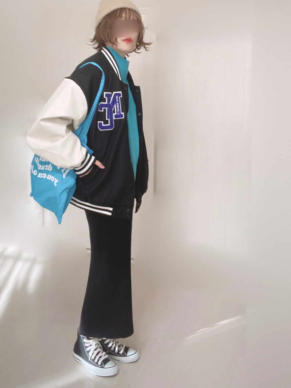 ブルー系のニット/セーター、ブラック系のスタジャン、ブルー系のトートバッグを着用したレディースの冬コーディネートの2枚目の写真