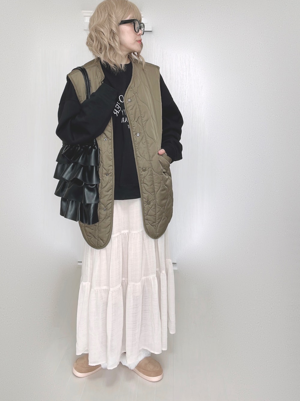 ブラック系のスウェット、ホワイト系のスカートを着用したレディースの秋コーディネートの2枚目の写真