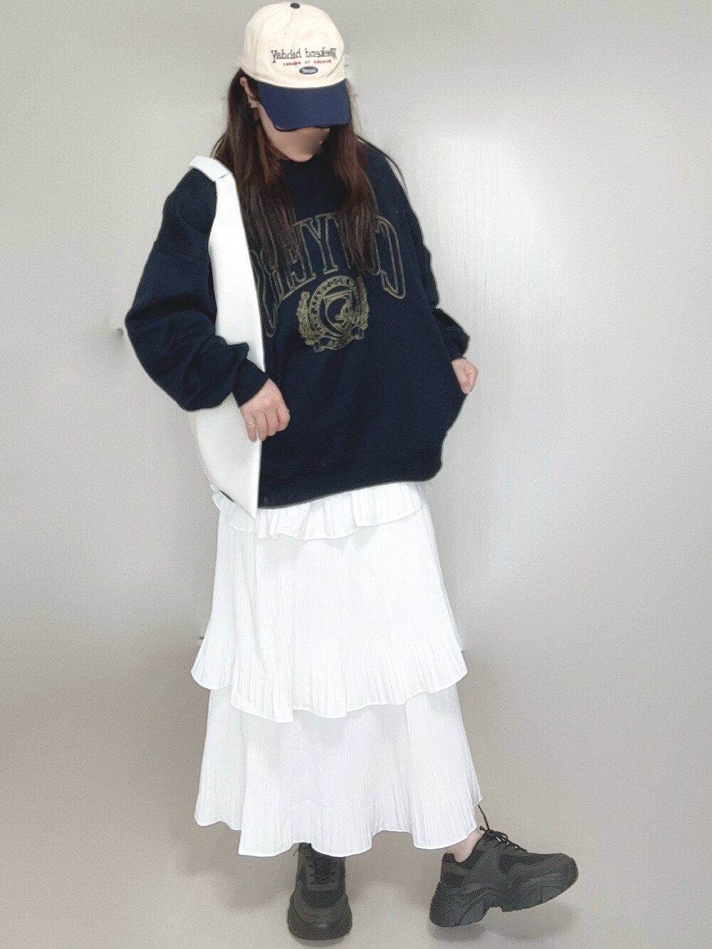 ブルー系のスウェット、ホワイト系のスカート、ホワイト系のショルダーバッグを着用したレディースの秋コーディネートの4枚目の写真