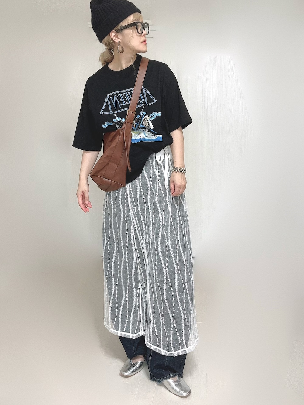 ブラック系のTシャツ/カットソー、ホワイト系のスカート、ブルー系のデニムパンツを着用したレディースの夏コーディネートの4枚目の写真