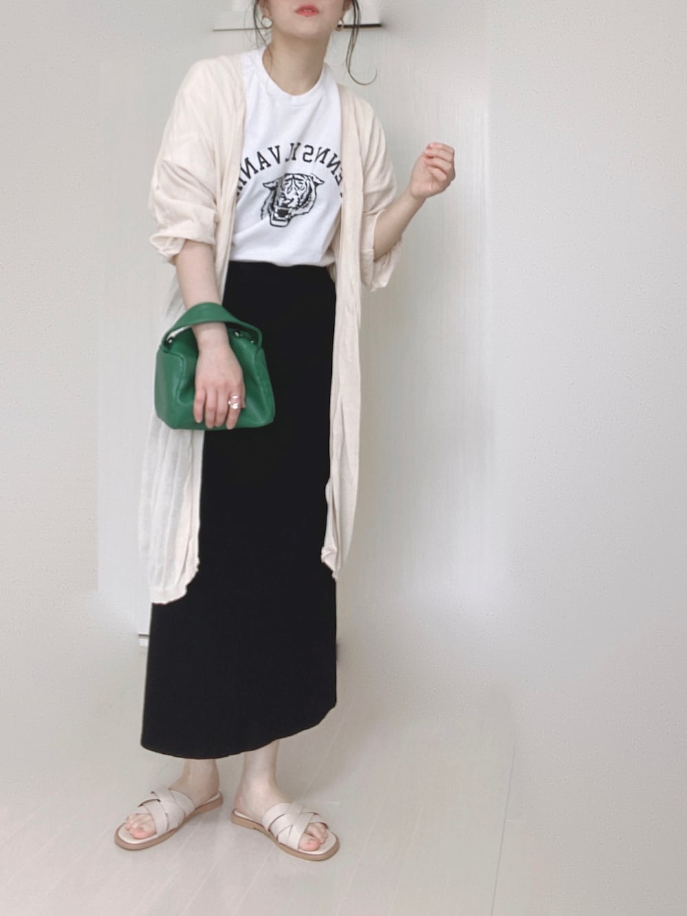 ホワイト系のサンダル、ホワイト系のTシャツ/カットソー、ベージュ系のカーディガン/ボレロを着用したレディースの春コーディネートの3枚目の写真