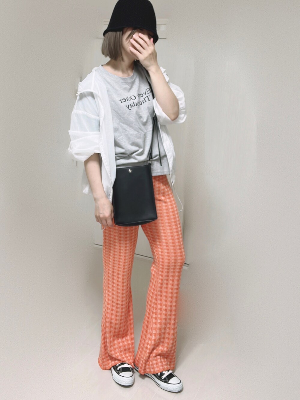 オレンジ系のその他パンツ、ブラック系のショルダーバッグ、ブラック系のスニーカーを着用したレディースの夏コーディネートの2枚目の写真