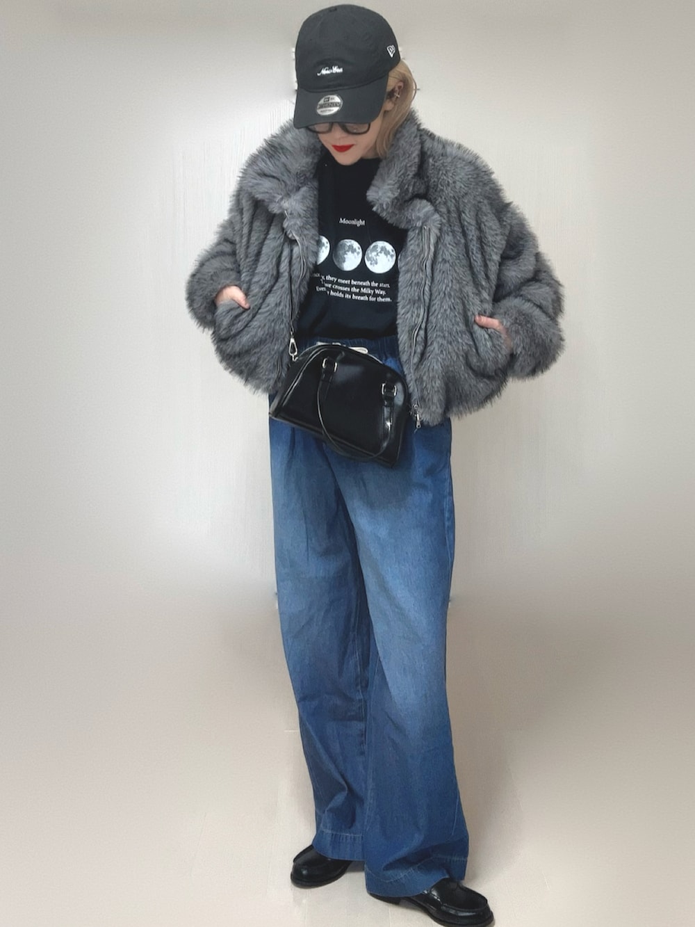 グレー系のブルゾン、ブラック系のTシャツ/カットソー、ブラック系のボストンバッグを着用したレディースの冬コーディネートの3枚目の写真