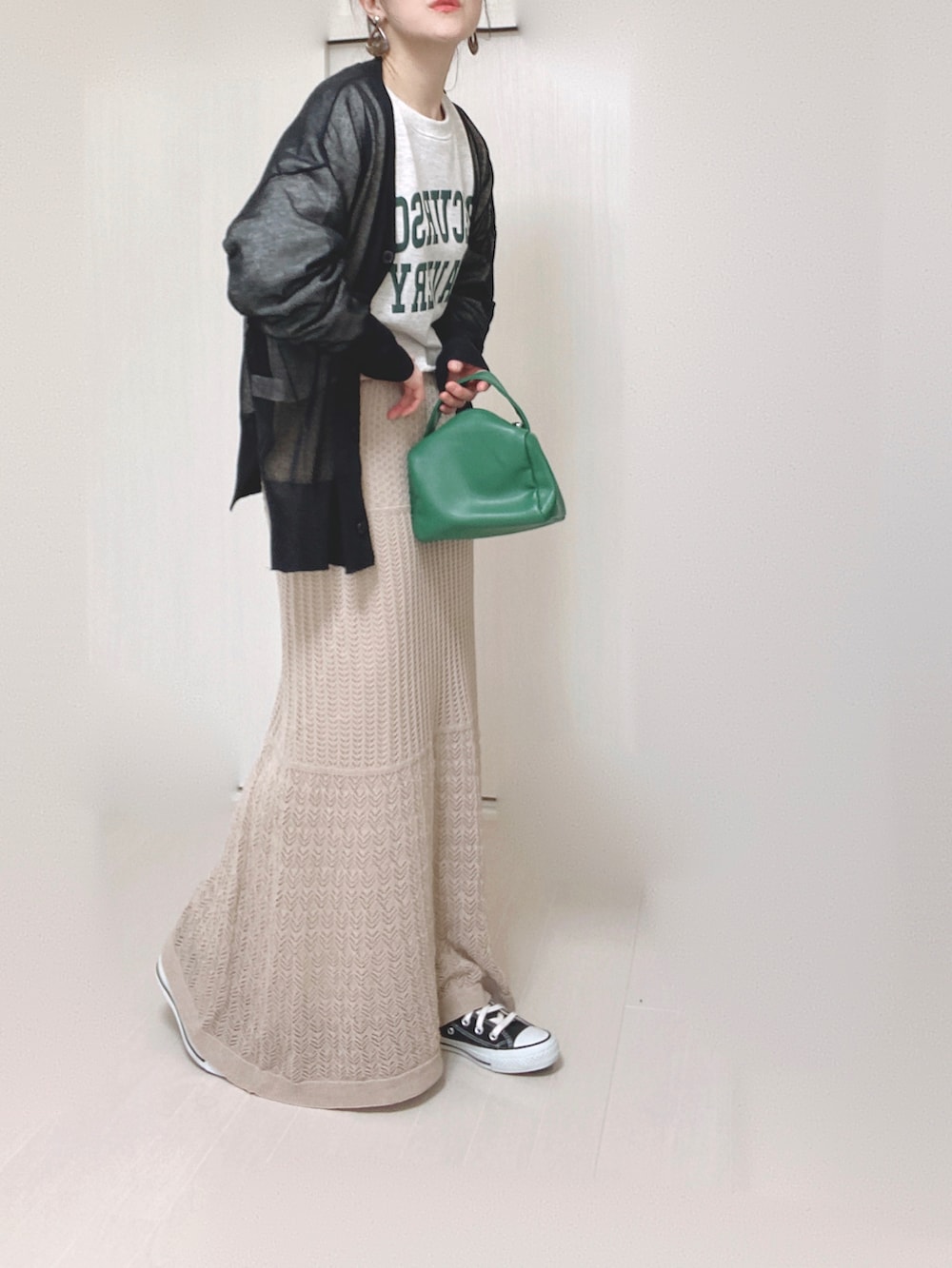 ブラック系のカーディガン/ボレロ、グリーン系のハンドバッグ、ブラック系のスニーカーを着用したレディースの春コーディネートの2枚目の写真