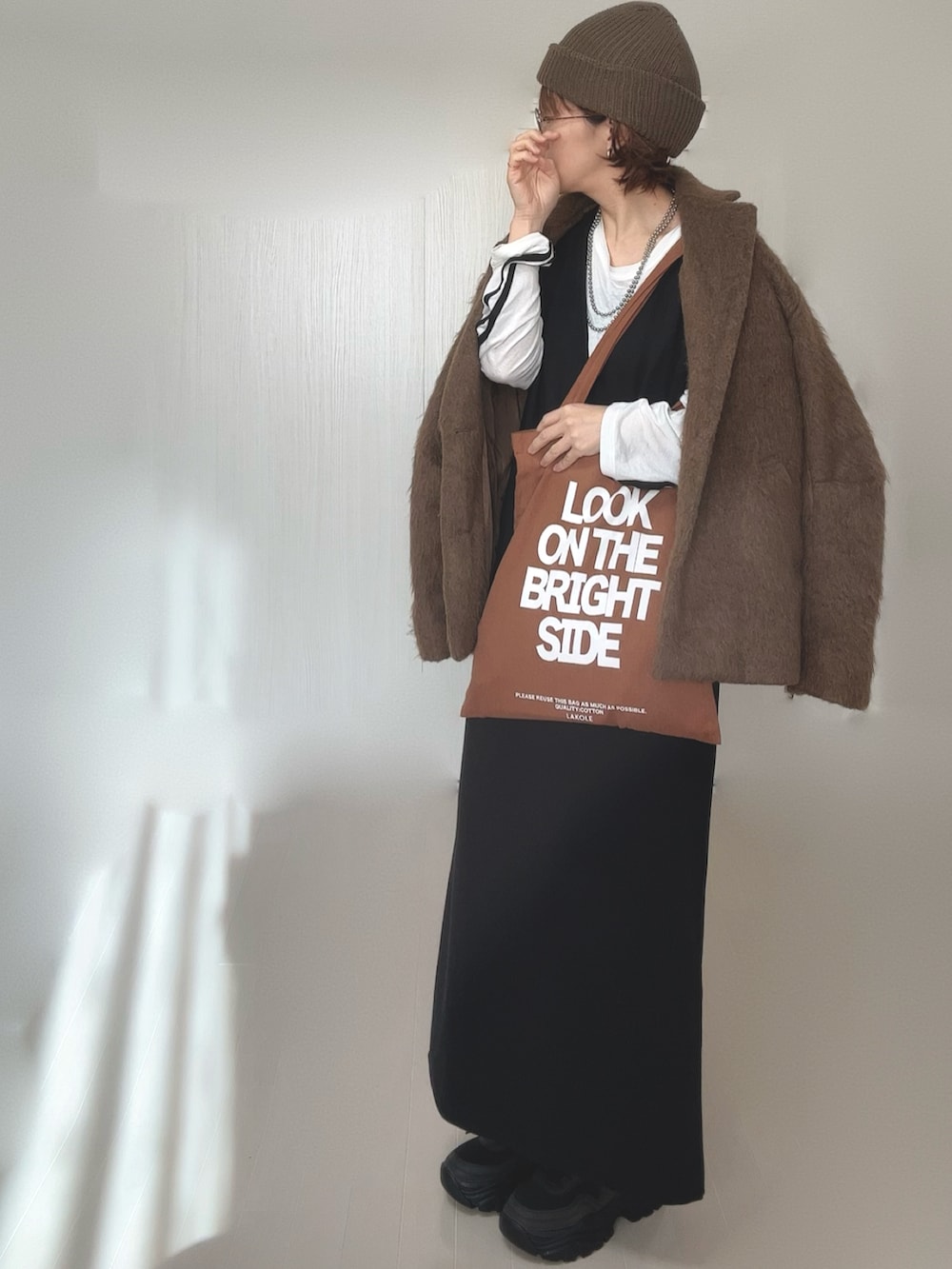 ホワイト系のTシャツ/カットソー、ブラウン系のテーラードジャケット、ブラック系のワンピースを着用したレディースの冬コーディネートの4枚目の写真