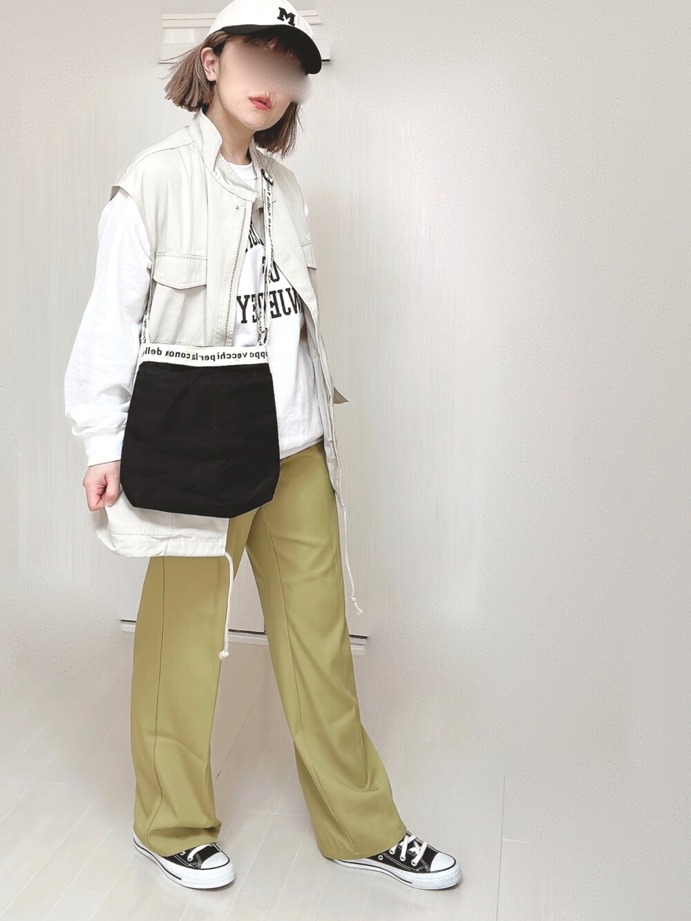 グリーン系のスラックス、ホワイト系のベスト、ホワイト系のスウェットを着用したレディースの春コーディネートの5枚目の写真