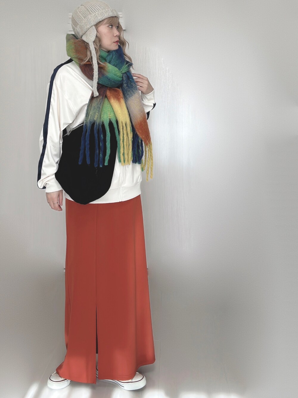 ベージュ系のジャージ、オレンジ系のスカート、ホワイト系のスニーカーを着用したレディースの秋コーディネートの4枚目の写真