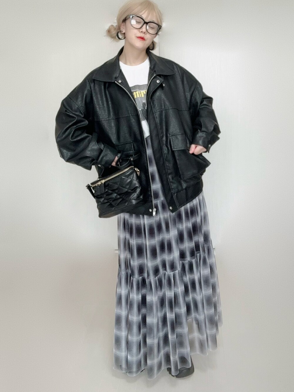 ブラック系のスカート、ブラック系のブルゾン、ホワイト系のTシャツ/カットソーを着用したレディースの秋コーディネートの5枚目の写真