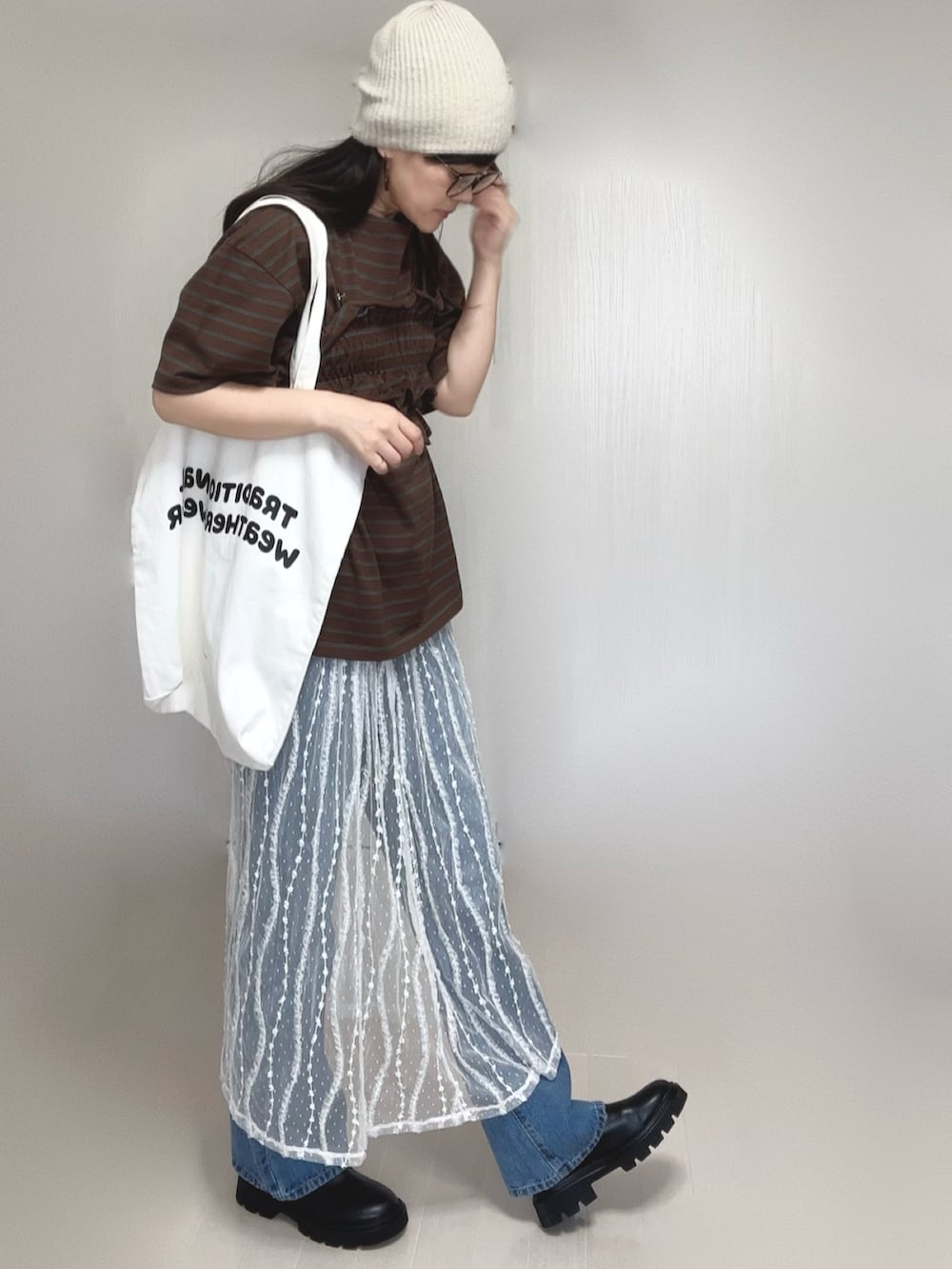 ブラウン系のTシャツ/カットソー、ブルー系のデニムパンツ、ホワイト系のスカートを着用したレディースの夏コーディネートの3枚目の写真