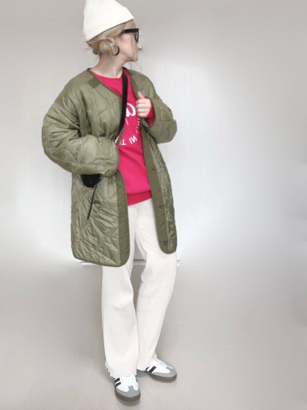 レッド系のスウェット、グリーン系のミリタリージャケット、ホワイト系のその他パンツを着用したレディースの冬コーディネートの4枚目の写真