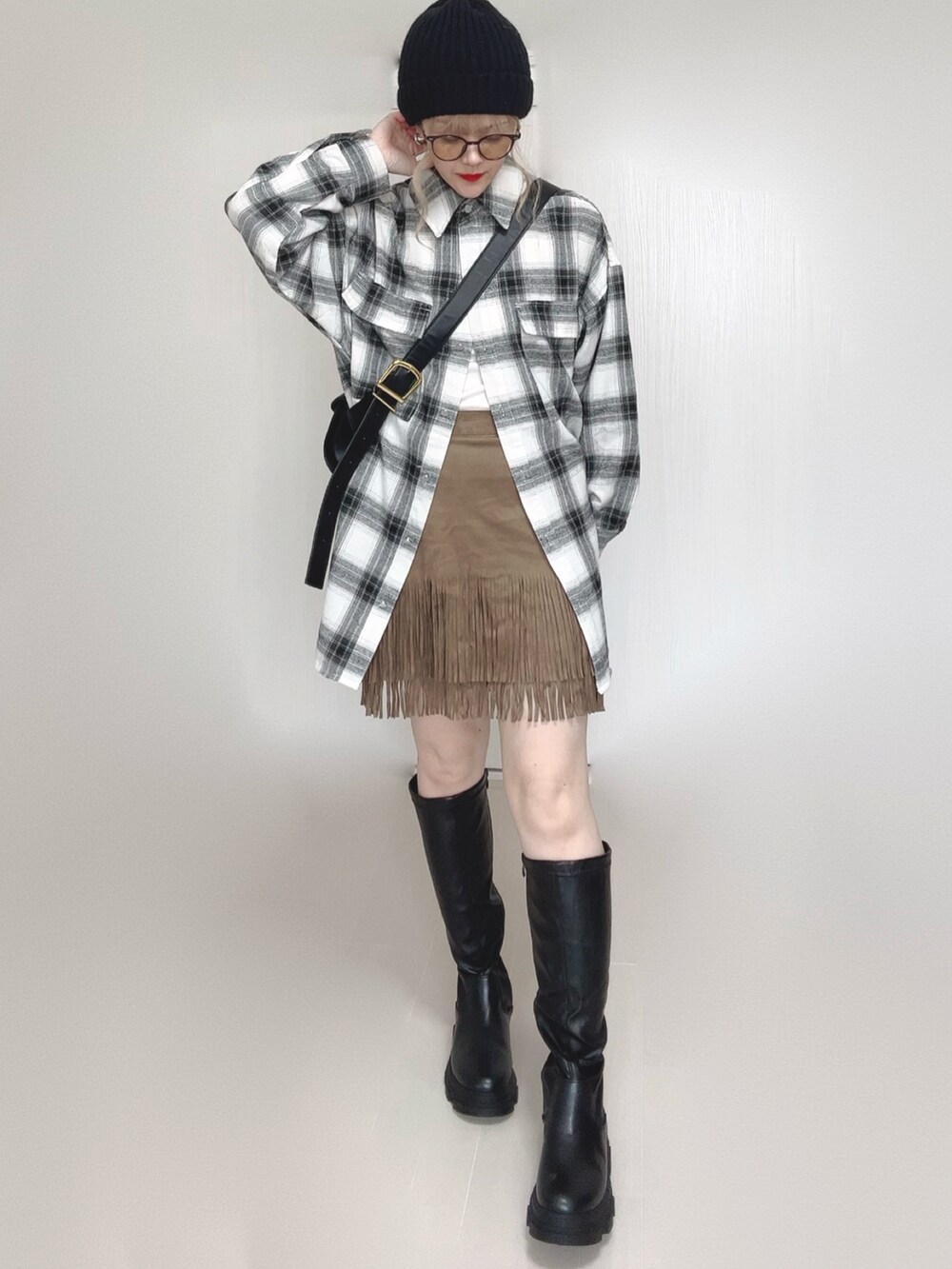 ホワイト系のシャツ/ブラウス、ベージュ系のスカート、ブラック系のブーツを着用したレディースの秋コーディネートの3枚目の写真