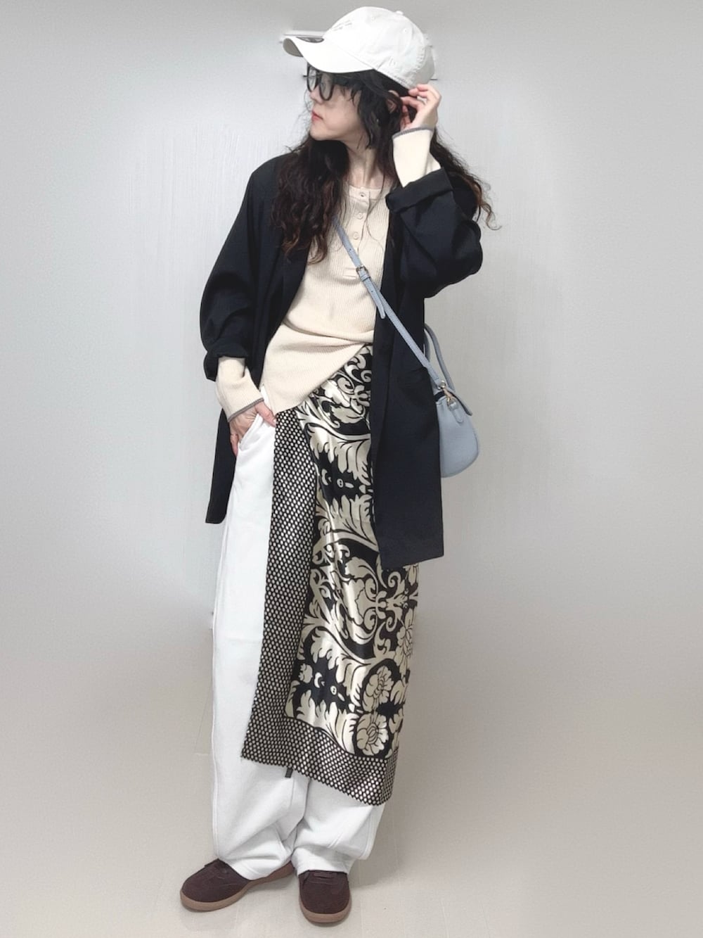 ブラック系のテーラードジャケット、ホワイト系のニット/セーター、その他のバンダナ/スカーフを着用したレディースの春コーディネートの2枚目の写真