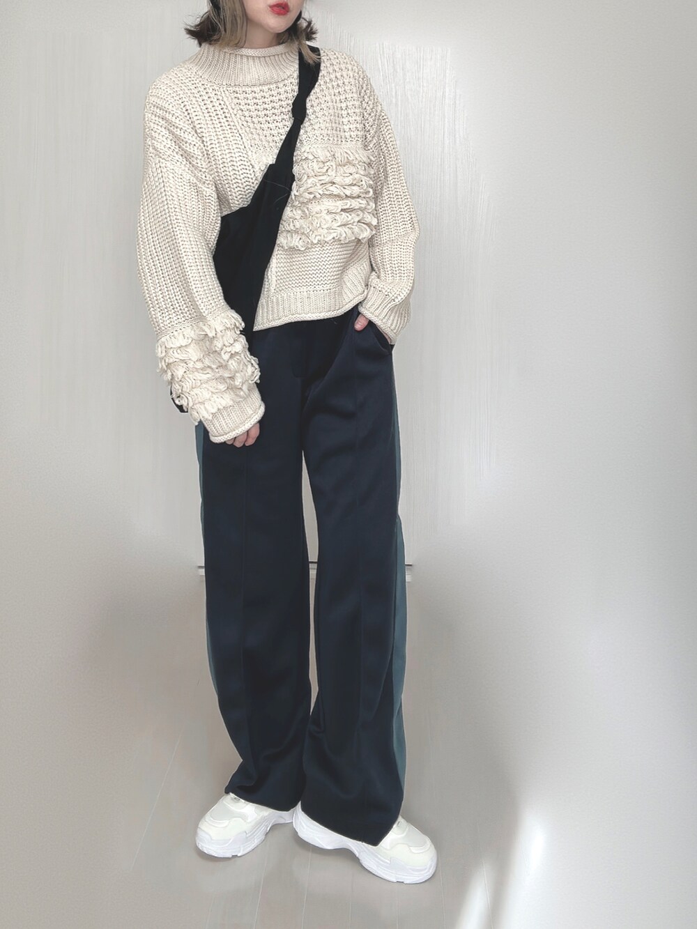 ブルー系のその他パンツ、ホワイト系のニット/セーター、ホワイト系のスニーカーを着用したレディースの秋コーディネートの3枚目の写真