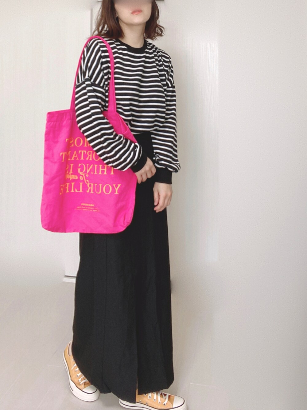 ブラック系のスカート、ホワイト系のTシャツ/カットソー、ピンク系のトートバッグを着用したレディースの秋コーディネートの4枚目の写真