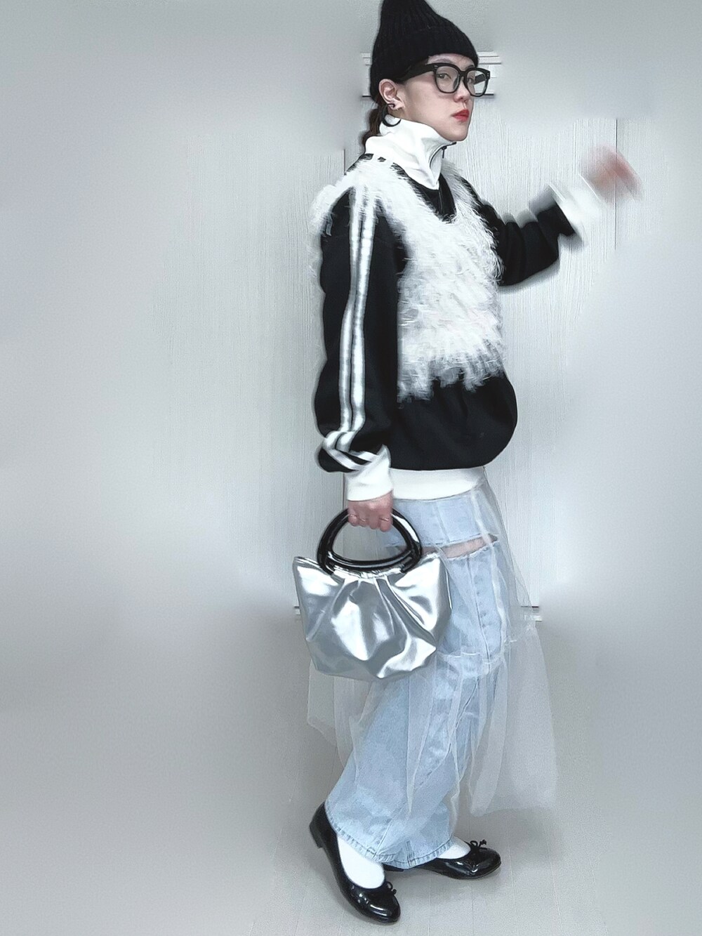 ブラック系のブルゾン、ホワイト系のベスト、ホワイト系のスカートを着用したレディースの春コーディネートの2枚目の写真