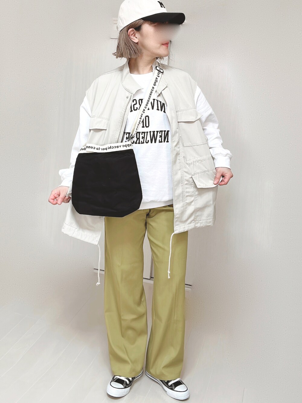 グリーン系のスラックス、ホワイト系のベスト、ホワイト系のスウェットを着用したレディースの春コーディネートの3枚目の写真