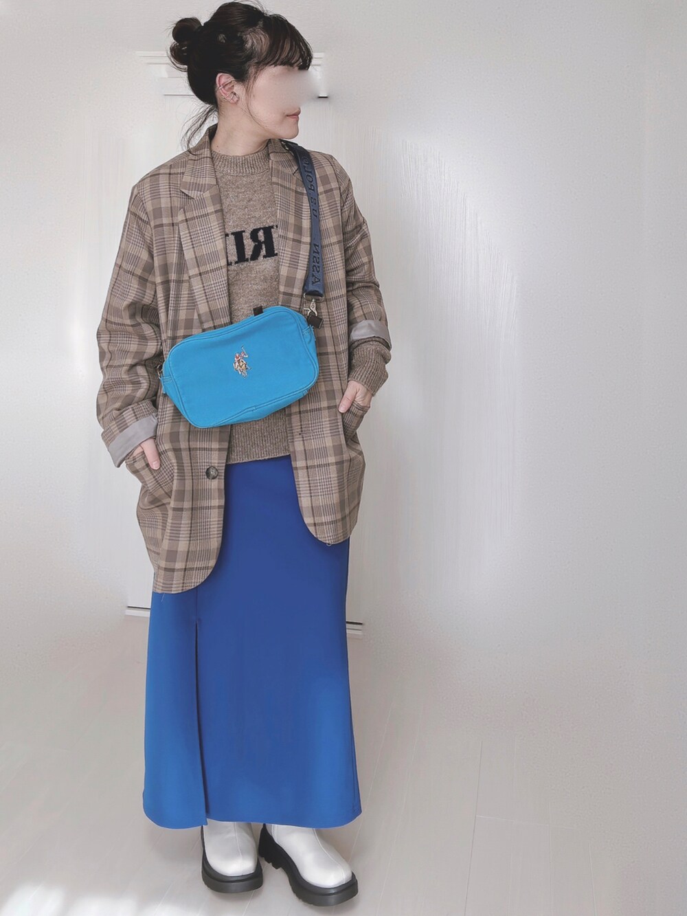 ブルー系のショルダーバッグ、ベージュ系のテーラードジャケット、ベージュ系のニット/セーターを着用したレディースの冬コーディネートの3枚目の写真