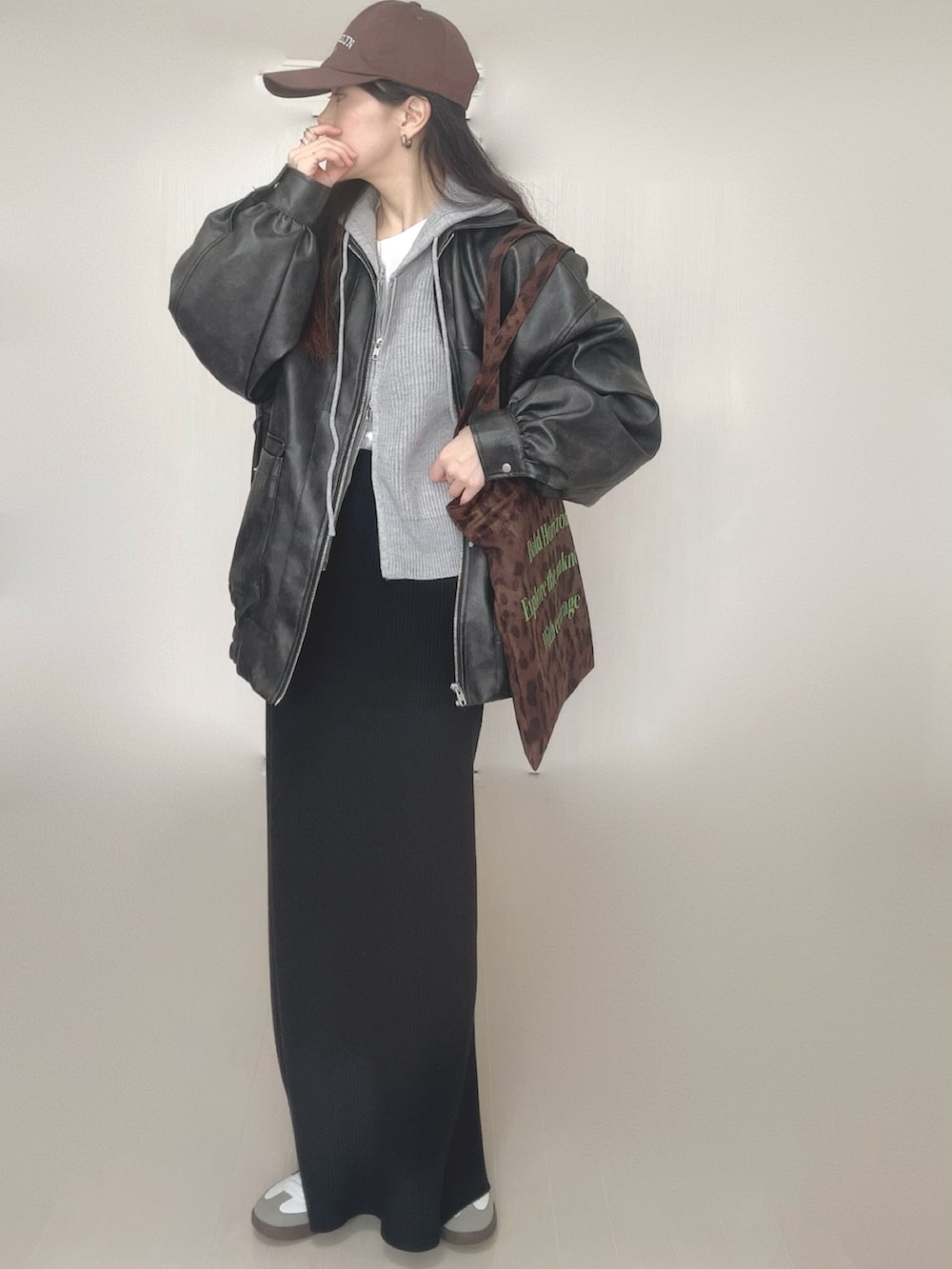 グレー系のパーカー、ブラック系のブルゾン、ブラウン系のトートバッグを着用したレディースの冬コーディネートの3枚目の写真