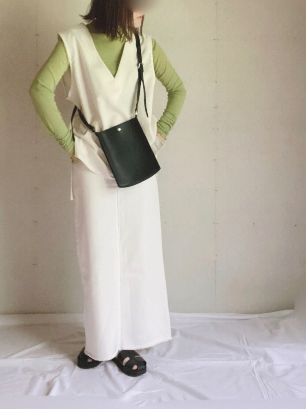 ベージュ系のデニムスカート、グリーン系のTシャツ/カットソー、ブラック系のショルダーバッグを着用したレディースの夏コーディネートの2枚目の写真