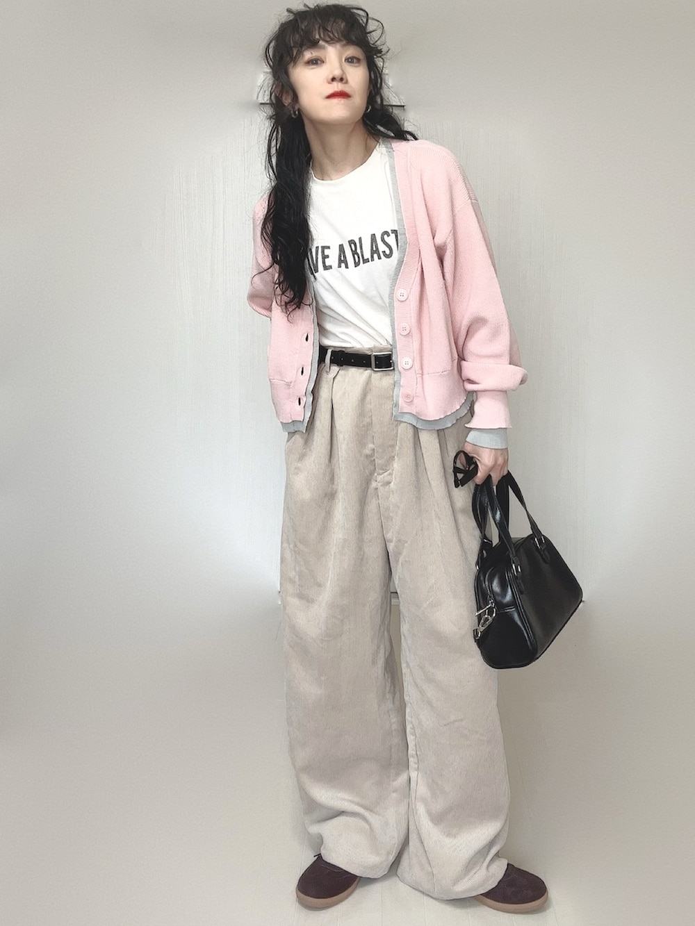 ピンク系のカーディガン/ボレロ、ホワイト系のTシャツ/カットソー、ブラック系のボストンバッグを着用したレディースの春コーディネートの5枚目の写真