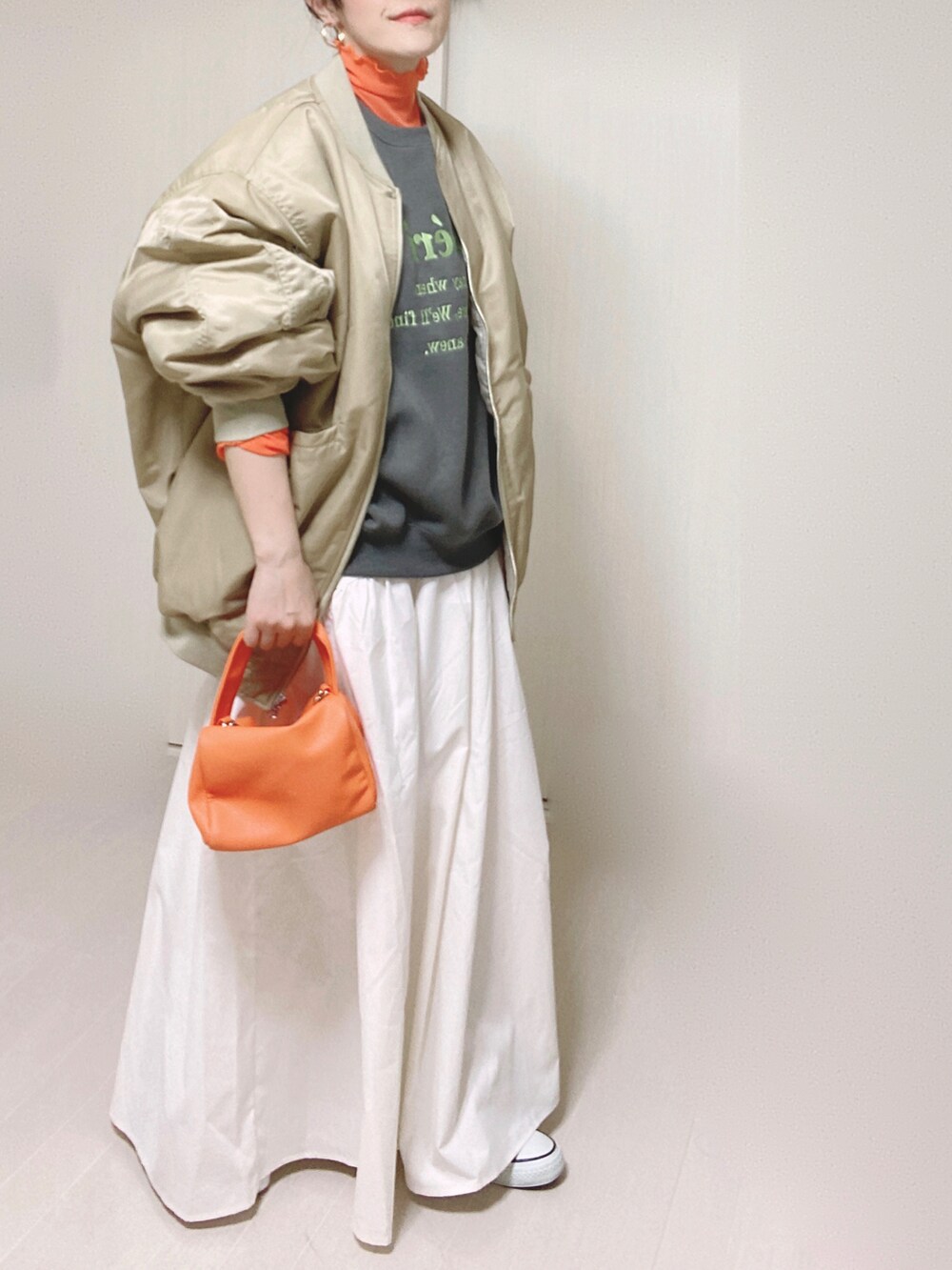 ベージュ系のMA-1、グレー系のスウェット、ホワイト系のスカートを着用したレディースの秋コーディネートの4枚目の写真