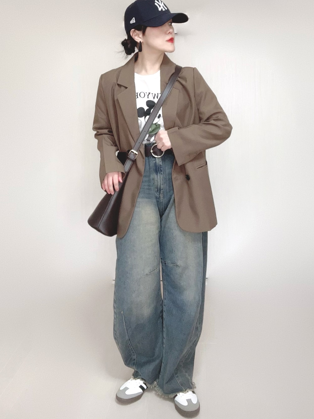 ブラウン系のテーラードジャケット、ホワイト系のTシャツ/カットソー、ブルー系のデニムパンツを着用したレディースの冬コーディネートの5枚目の写真