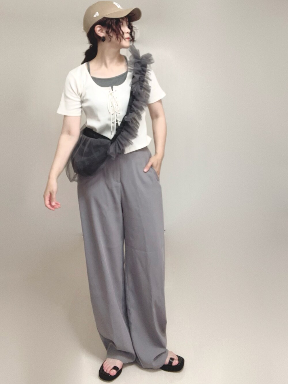 グレー系のその他パンツ、ブラック系のサンダル、ホワイト系のTシャツ/カットソーを着用したレディースの夏コーディネートの4枚目の写真