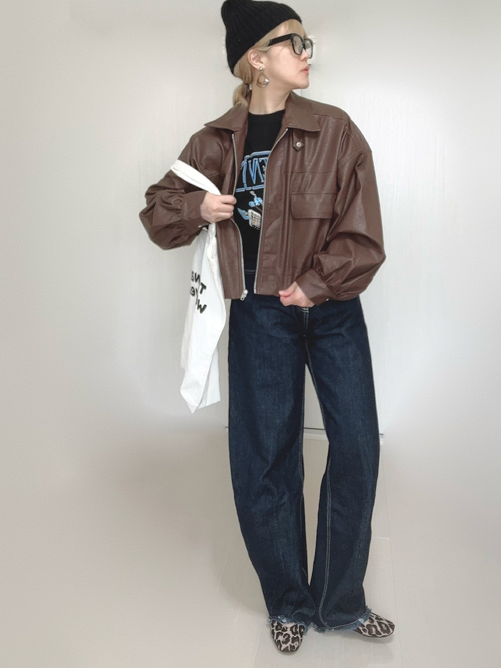 ブラウン系のブルゾン、ブラック系のTシャツ/カットソー、ホワイト系のトートバッグを着用したレディースの秋コーディネートの2枚目の写真