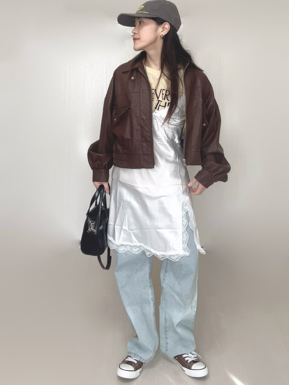 ベージュ系のTシャツ/カットソー、ブラウン系のブルゾン、ホワイト系のワンピースを着用したレディースの冬コーディネートの5枚目の写真