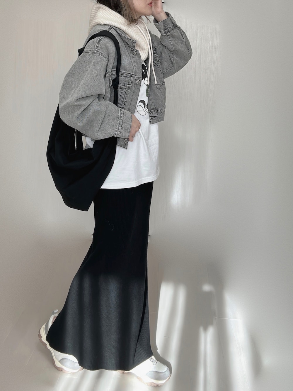 ブラック系のデニムジャケット、ホワイト系のTシャツ/カットソー、ブラック系のスカートを着用したレディースの冬コーディネートの5枚目の写真