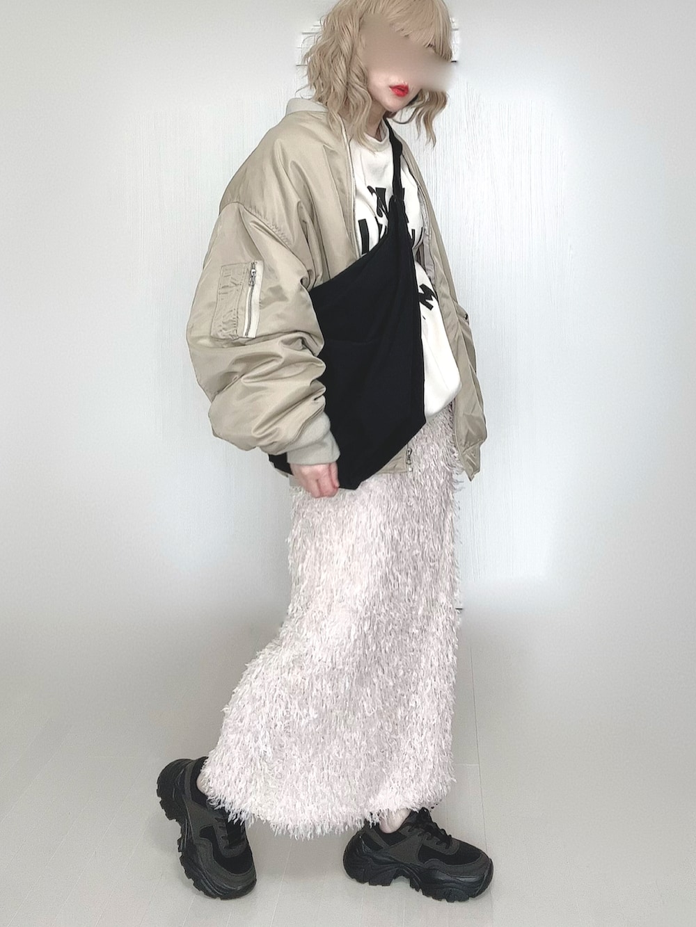 ベージュ系のMA-1、ブラック系のスニーカー、イエロー系のメガネを着用したレディースの春コーディネートの2枚目の写真