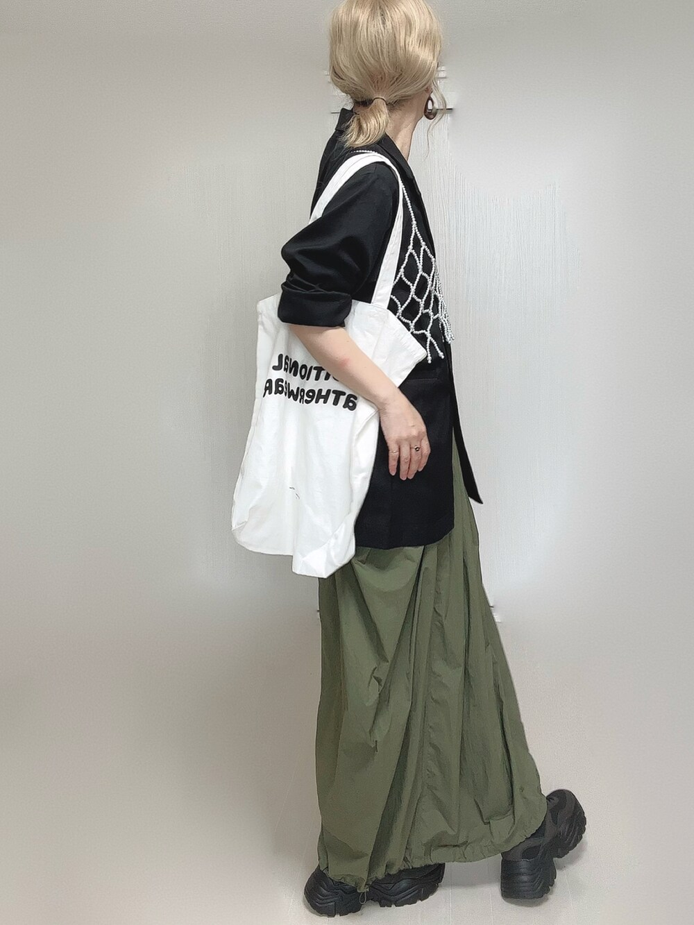 ブラック系のテーラードジャケット、ブラック系のキャミソール、ホワイト系のベストを着用したレディースの夏コーディネートの3枚目の写真