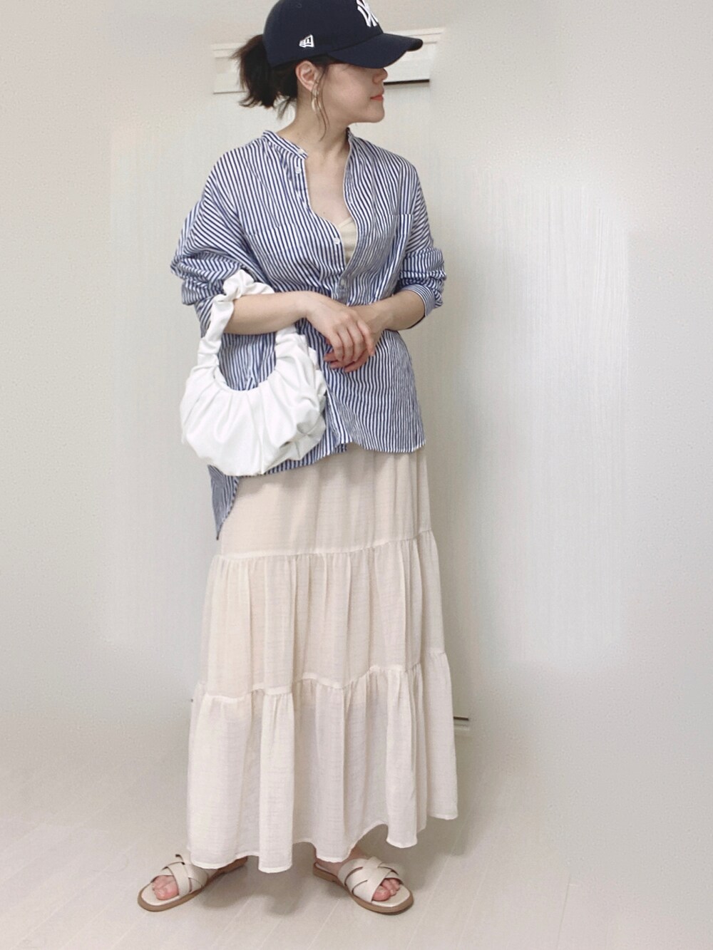 ホワイト系のキャミソール、ホワイト系のスカート、ホワイト系のサンダルを着用したレディースの夏コーディネートの3枚目の写真