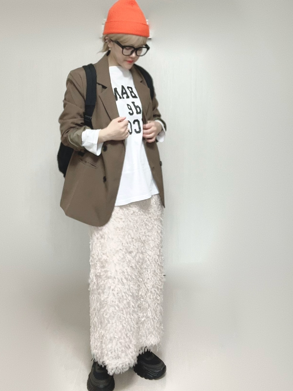 ホワイト系のTシャツ/カットソー、ブラウン系のテーラードジャケット、ブラック系のスニーカーを着用したレディースの春コーディネートの4枚目の写真