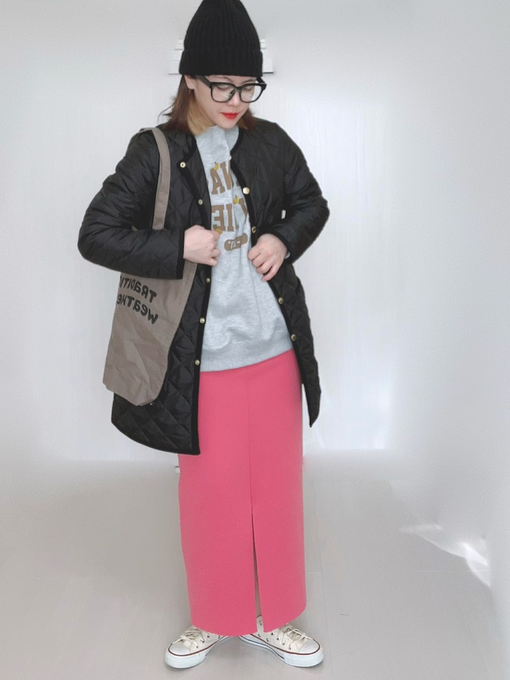 グレー系のスウェット、ブラック系のノーカラーコート、ブラウン系のトートバッグを着用したレディースの冬コーディネートの4枚目の写真