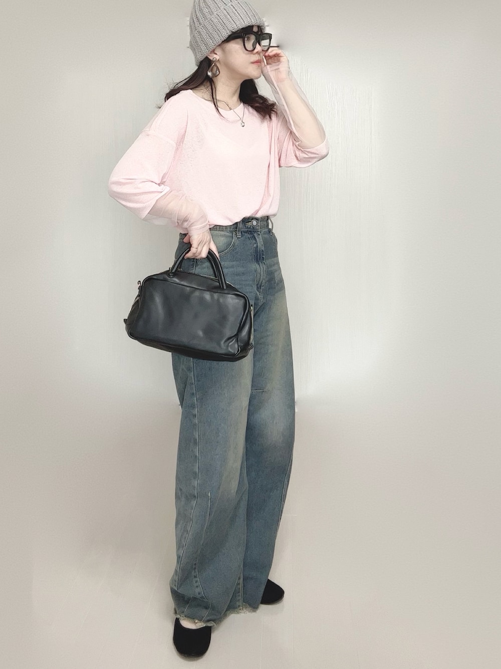 ピンク系のTシャツ/カットソー、ブルー系のデニムパンツ、ブラック系のボストンバッグを着用したレディースの春コーディネートの5枚目の写真