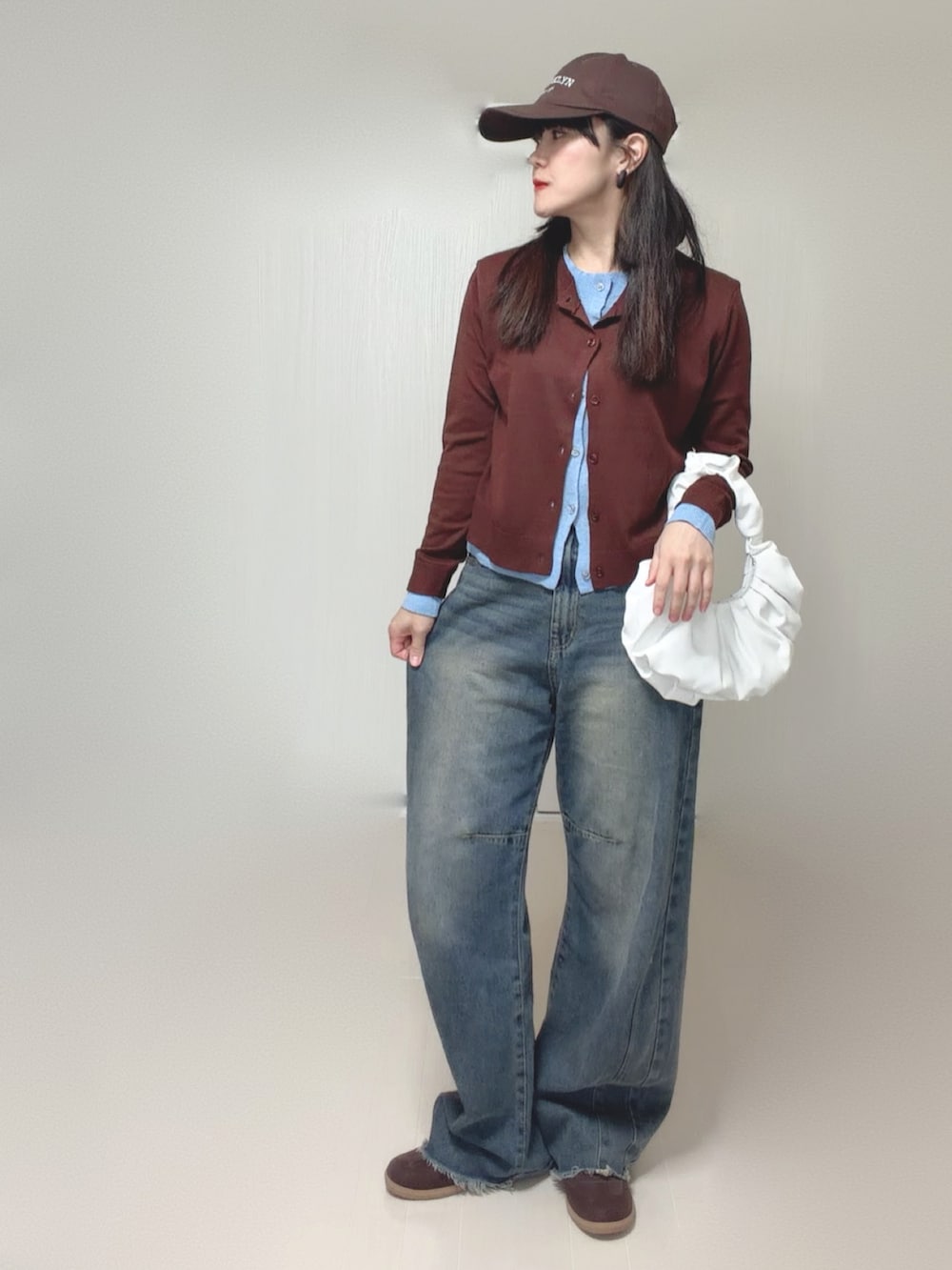 ブラウン系のカーディガン/ボレロ、ブルー系のデニムパンツを着用したレディースの秋コーディネートの4枚目の写真