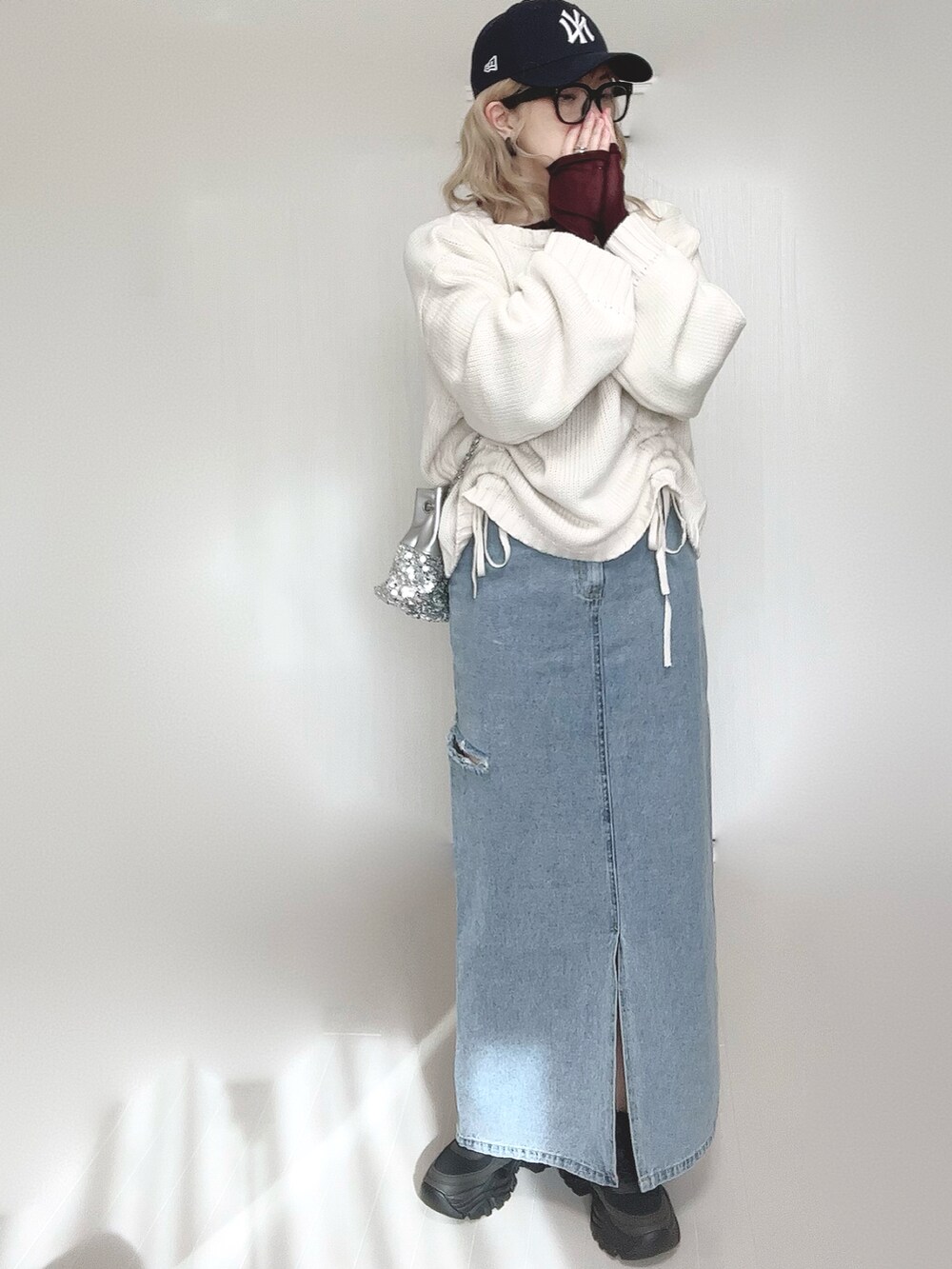 ホワイト系のニット/セーター、ブラウン系のTシャツ/カットソー、シルバー系のショルダーバッグを着用したレディースの冬コーディネートの3枚目の写真