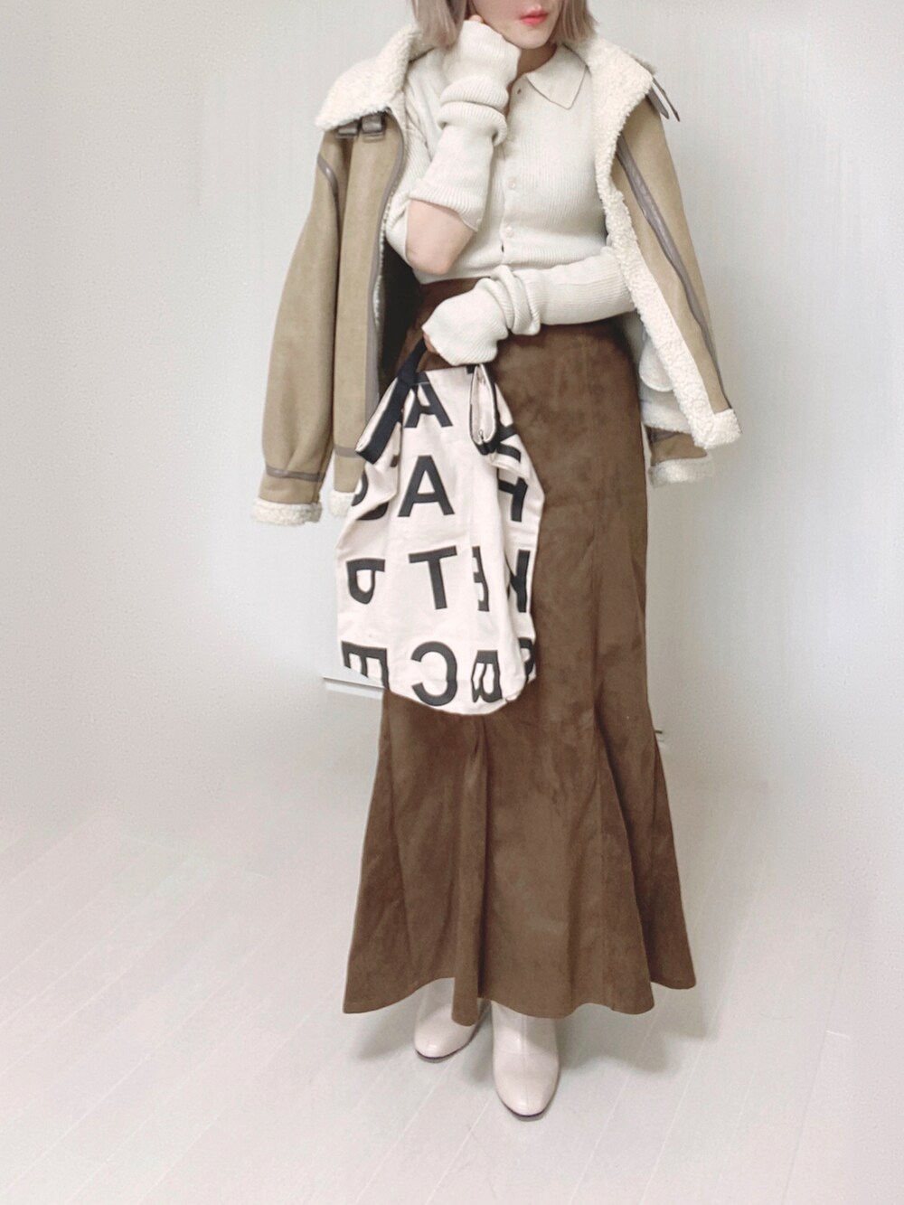ホワイト系のカーディガン/ボレロ、ベージュ系のムートンコート、ホワイト系のトートバッグを着用したレディースの秋コーディネートの5枚目の写真