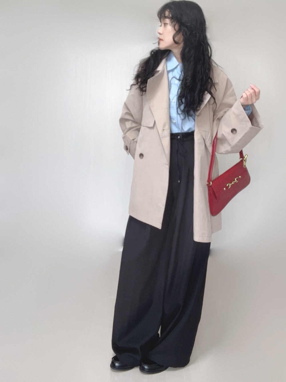 ベージュ系のトレンチコート、ブラック系のスラックス、ブラック系のローファーを着用したレディースの春コーディネートの3枚目の写真