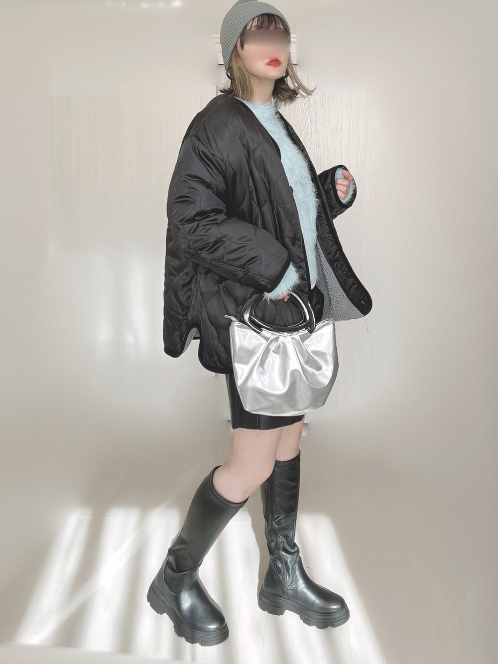 ブルー系のニット/セーター、ブラック系のブーツ、グレー系のノーカラージャケットを着用したレディースの秋コーディネートの2枚目の写真