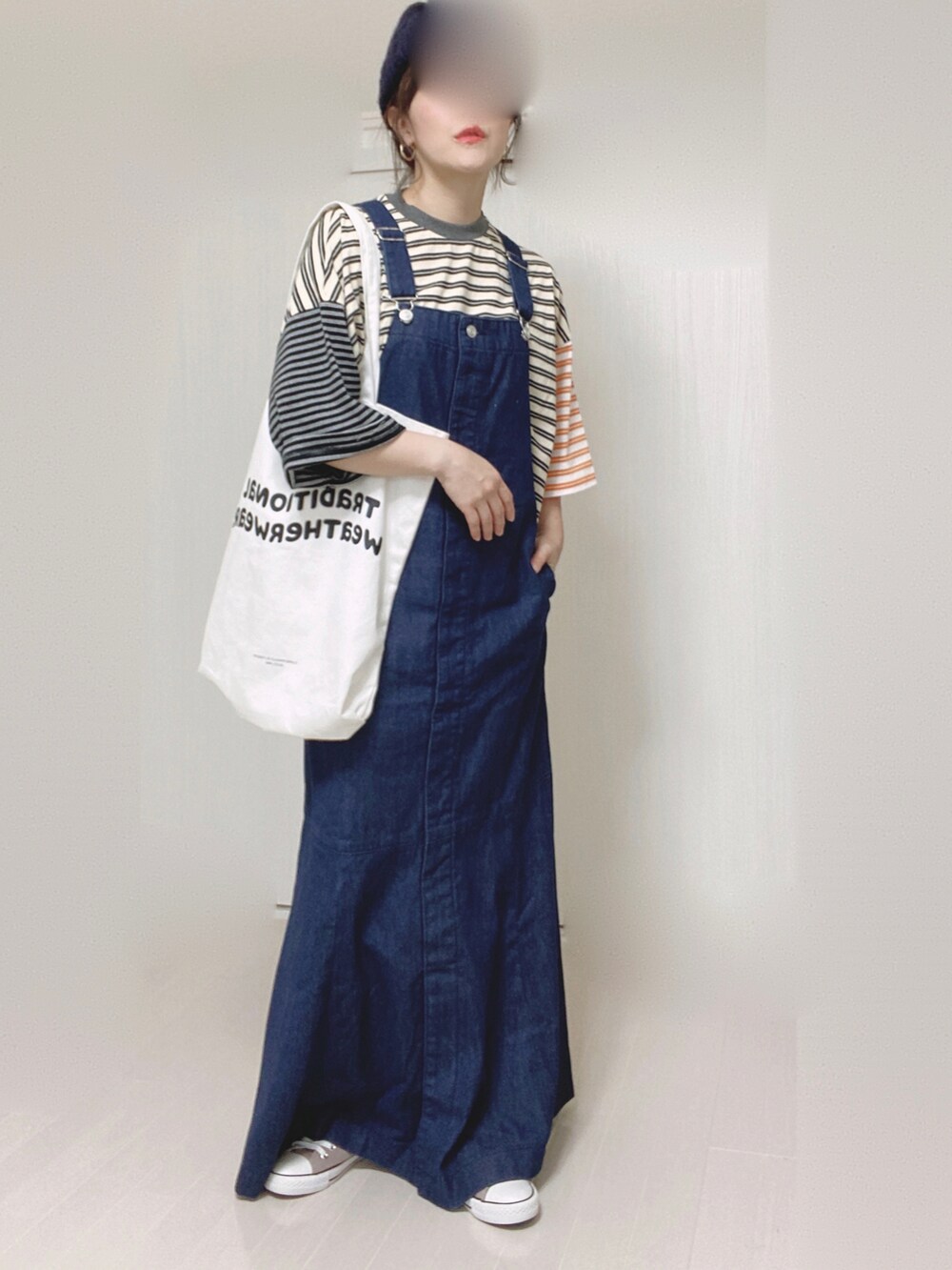 ブルー系のジャンパースカート、ベージュ系のTシャツ/カットソー、ホワイト系のトートバッグを着用したレディースの夏コーディネートの2枚目の写真