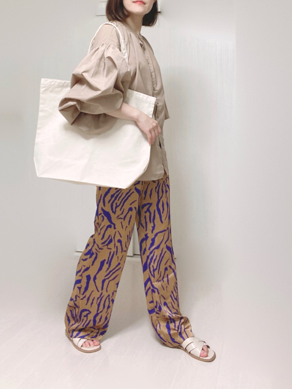 ホワイト系のトートバッグ、ベージュ系のシャツ/ブラウス、オレンジ系のその他パンツを着用したレディースの夏コーディネートの5枚目の写真
