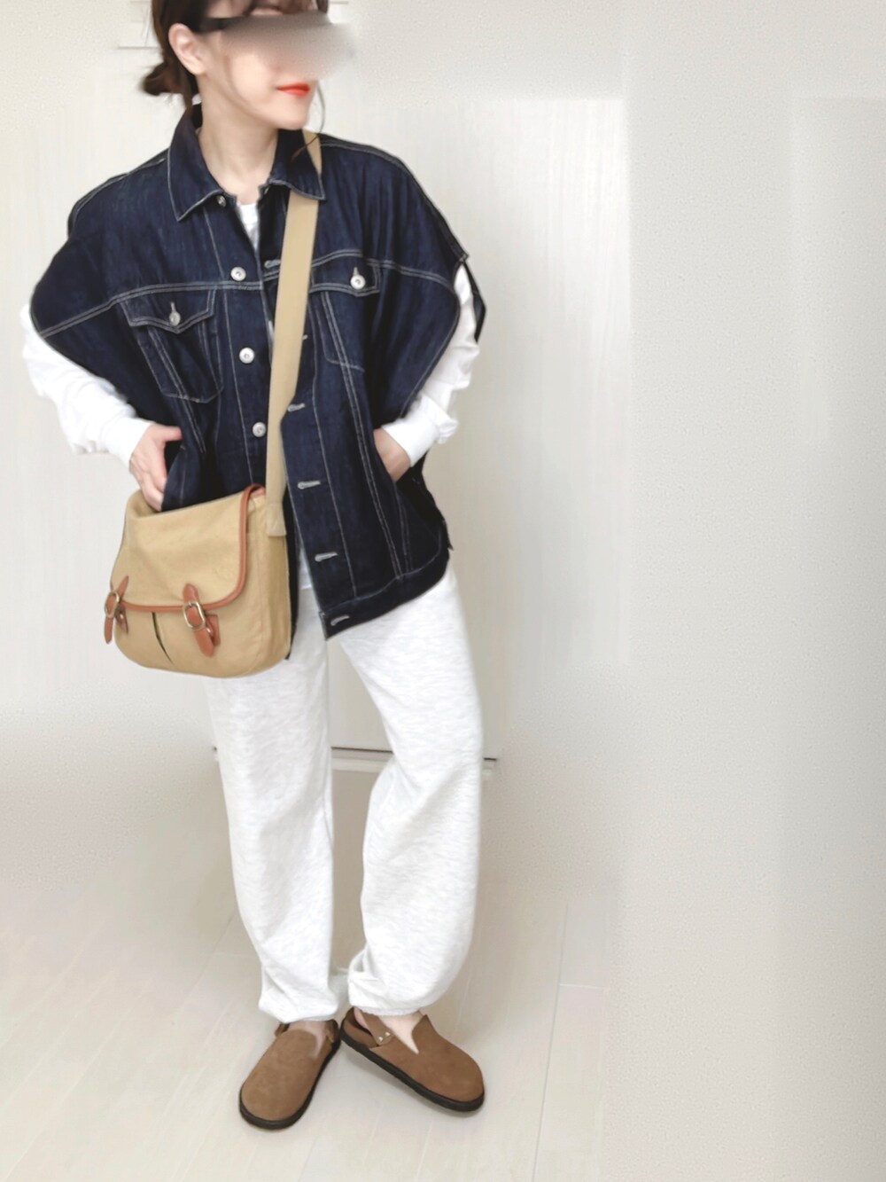 ブルー系のベスト、ホワイト系のTシャツ/カットソー、ベージュ系のショルダーバッグを着用したレディースの春コーディネートの3枚目の写真