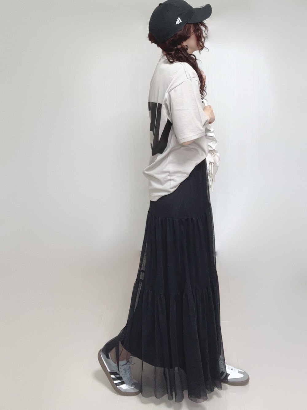 ベージュ系のTシャツ/カットソー、ホワイト系のショルダーバッグ、ブラック系のスカートを着用したレディースの夏コーディネートの2枚目の写真