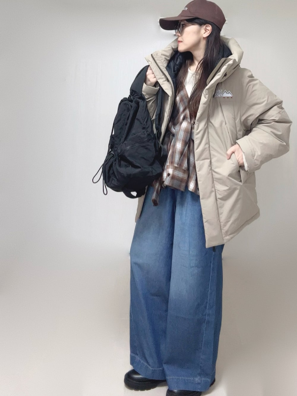 ベージュ系のダウンジャケット/コート、ブラウン系のシャツ/ブラウス、ベージュ系のTシャツ/カットソーを着用したレディースの冬コーディネートの3枚目の写真