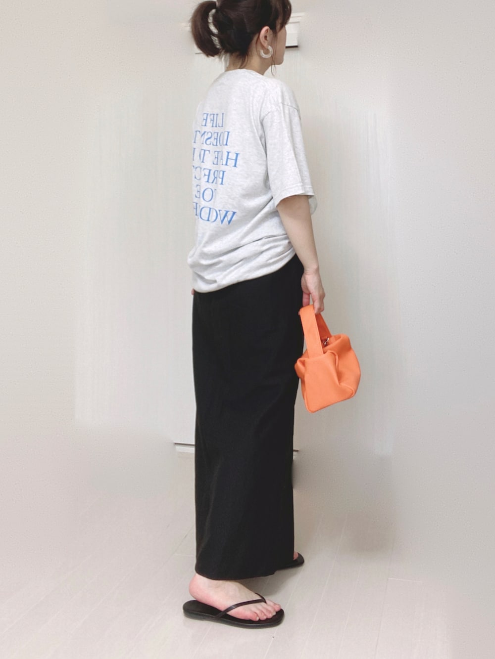 ベージュ系のTシャツ/カットソー、ブラック系のスカート、オレンジ系のショルダーバッグを着用したレディースの夏コーディネートの4枚目の写真